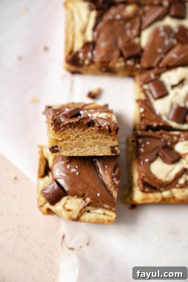 A slice of Nutella blondie revealing its rich, chewy interior and Nutella swirl.