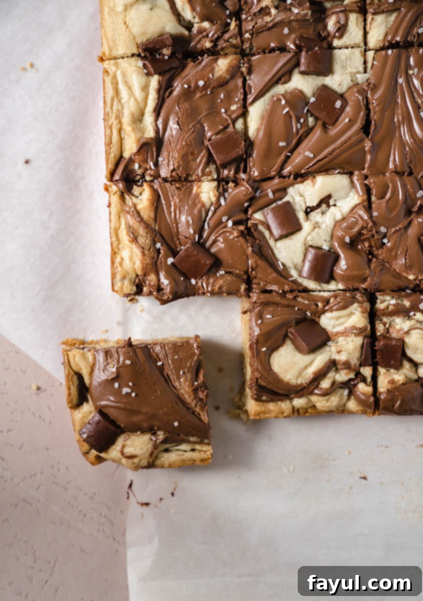Several Nutella blondies neatly cut into squares on a serving plate.