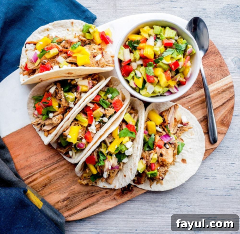 Tacos on a wooden cutting board with a bowl of salsa and silver spoon on the right.