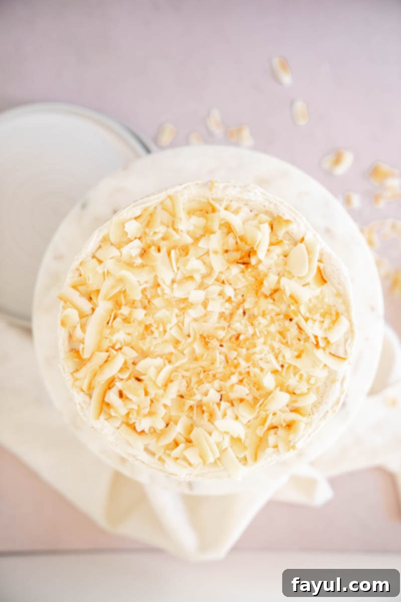 An overhead shot of a beautifully decorated Coconut Caramel Pecan Cake, garnished with toasted coconut flakes.