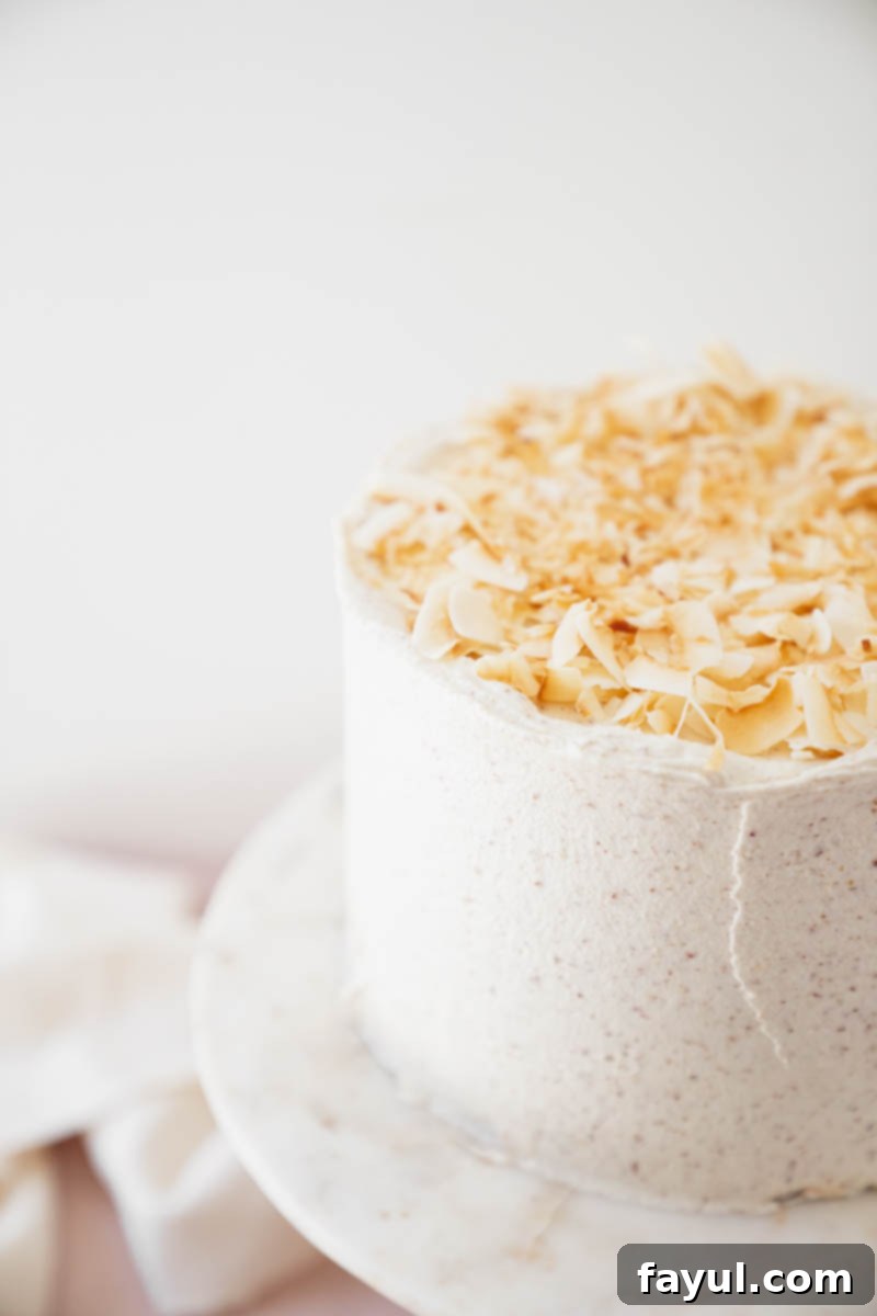 Close-up of a generously frosted Coconut Caramel Pecan Cake, highlighting the smooth pecan buttercream.