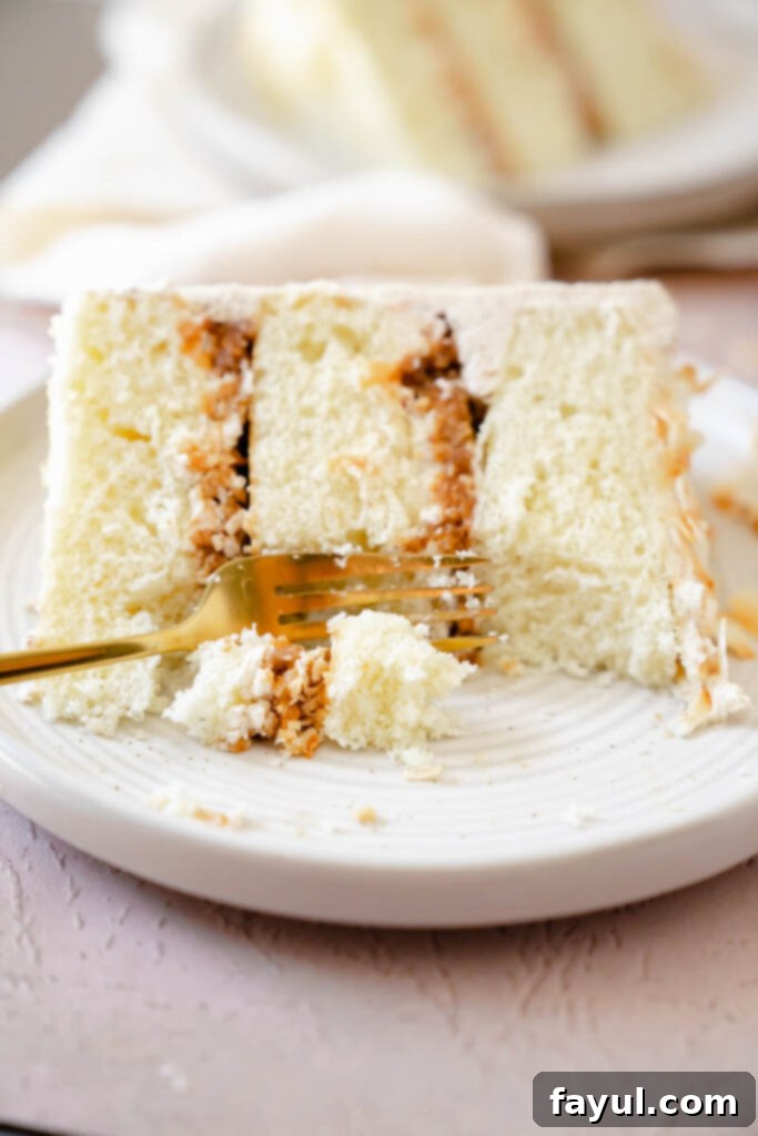 A beautifully assembled Coconut Caramel Pecan Cake, showing the layers of cake, filling, and frosting before final decoration.
