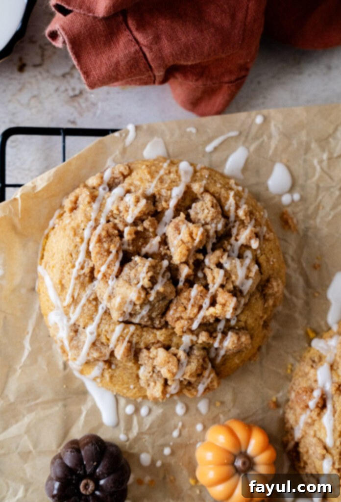 Two pumpkin coffee cake cookies stacked, with streusel and icing visible.