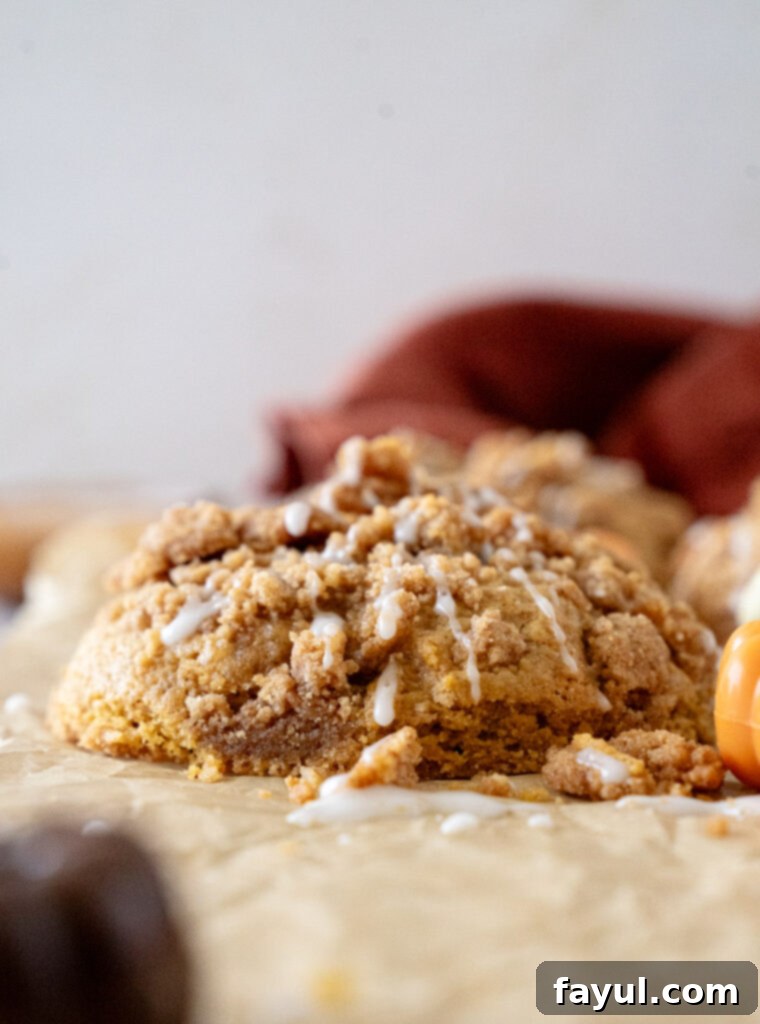 Close-up of a pumpkin coffee cake cookie being drizzled with icing.