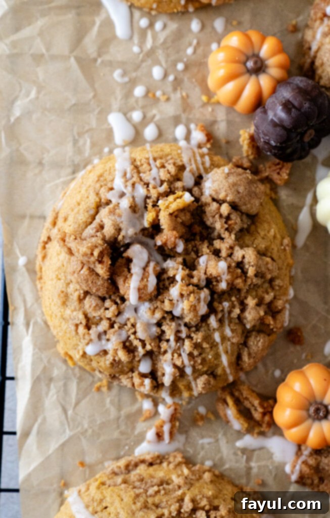 A freshly baked pumpkin coffee cake cookie on a cooling rack, showing its crumbly topping and soft texture.