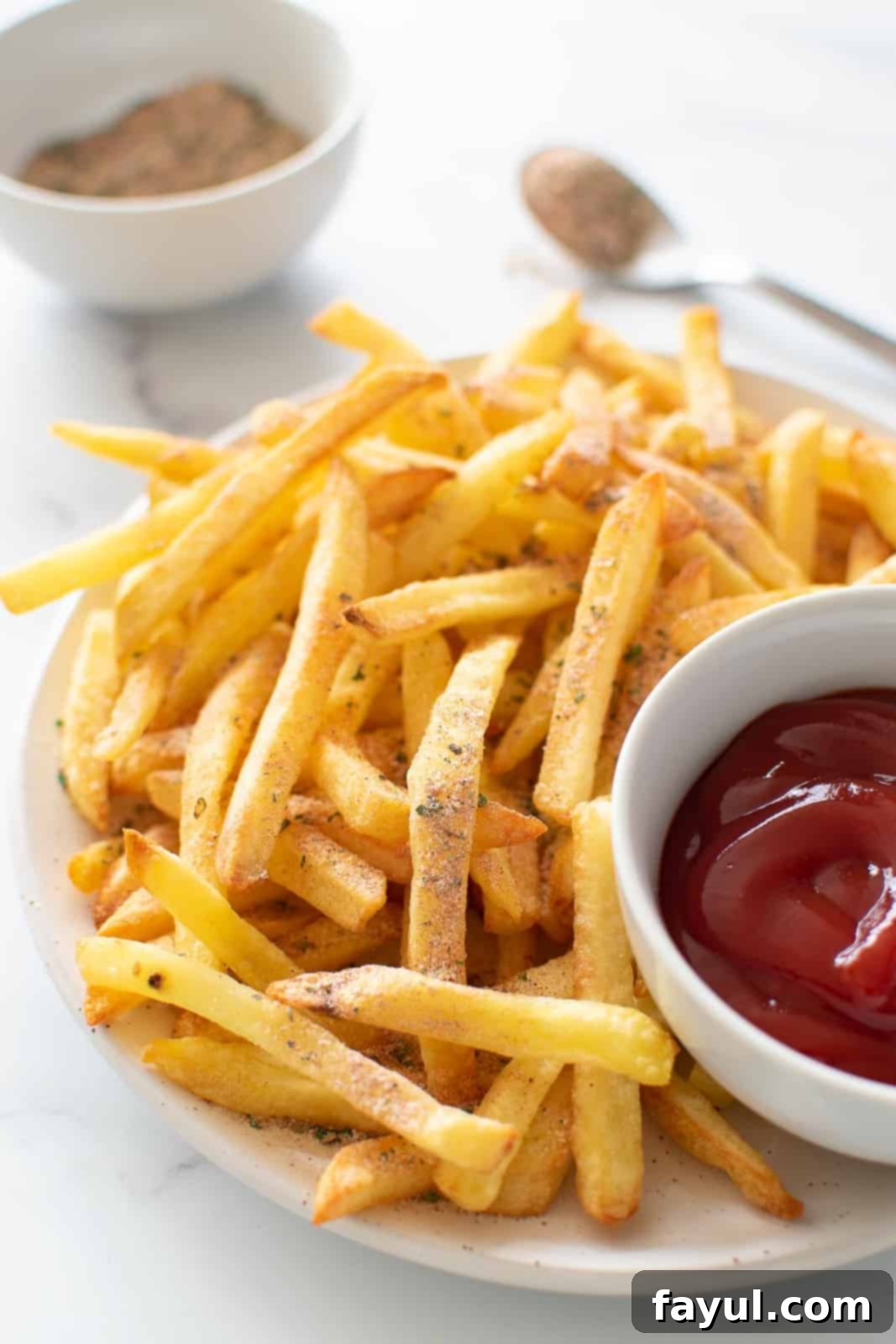 French fries perfectly seasoned with homemade spice blend, ready to eat.