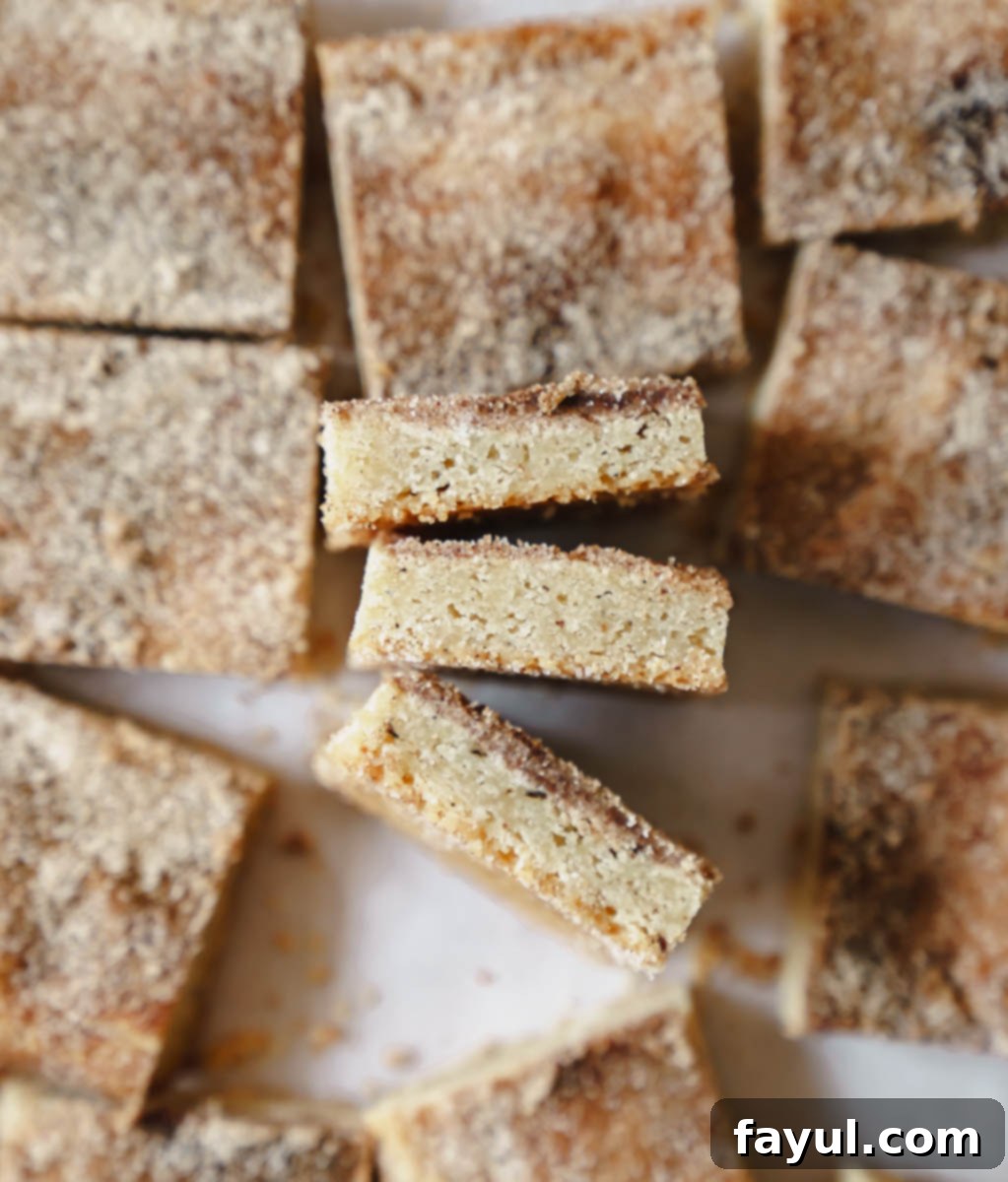 Various Brown Butter Snickerdoodle Blondies displayed on a rustic wooden board, ready for serving.