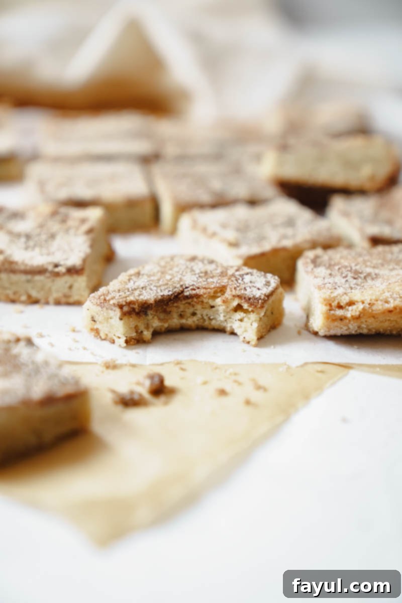 Unbaked Brown Butter Snickerdoodle Blondies dough in a parchment-lined baking pan, ready for the oven.