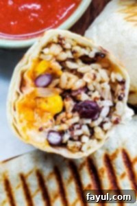 This healthy and easy Vegetarian Burritos recipe is freezer friendly, perfect for meal prep, to make ahead, and super delicious. Packed with black beans, brown rice, quinoa, veggies, cheese and Mexican spices this will be a new family dinner or lunch favorite. Pair with salsa, sour cream or guacamole for the best finish! {VIDEO} #burritos #vegetarian #healthy #mealprep #freezermeal