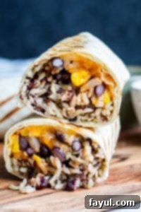 Strait on shot of cut burritos stacked on top of each other on a wooden cutting board. 