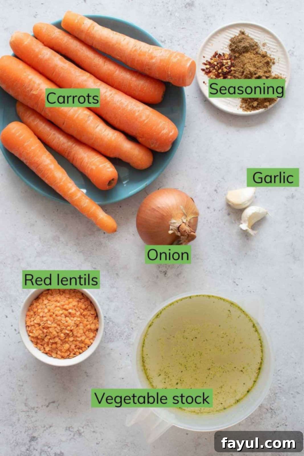 A flat lay image displaying all the fresh and affordable ingredients needed to make a delicious carrot lentil soup.
