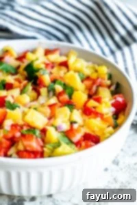 Salsa in a white bowl with a blue and white striped towel in background. 