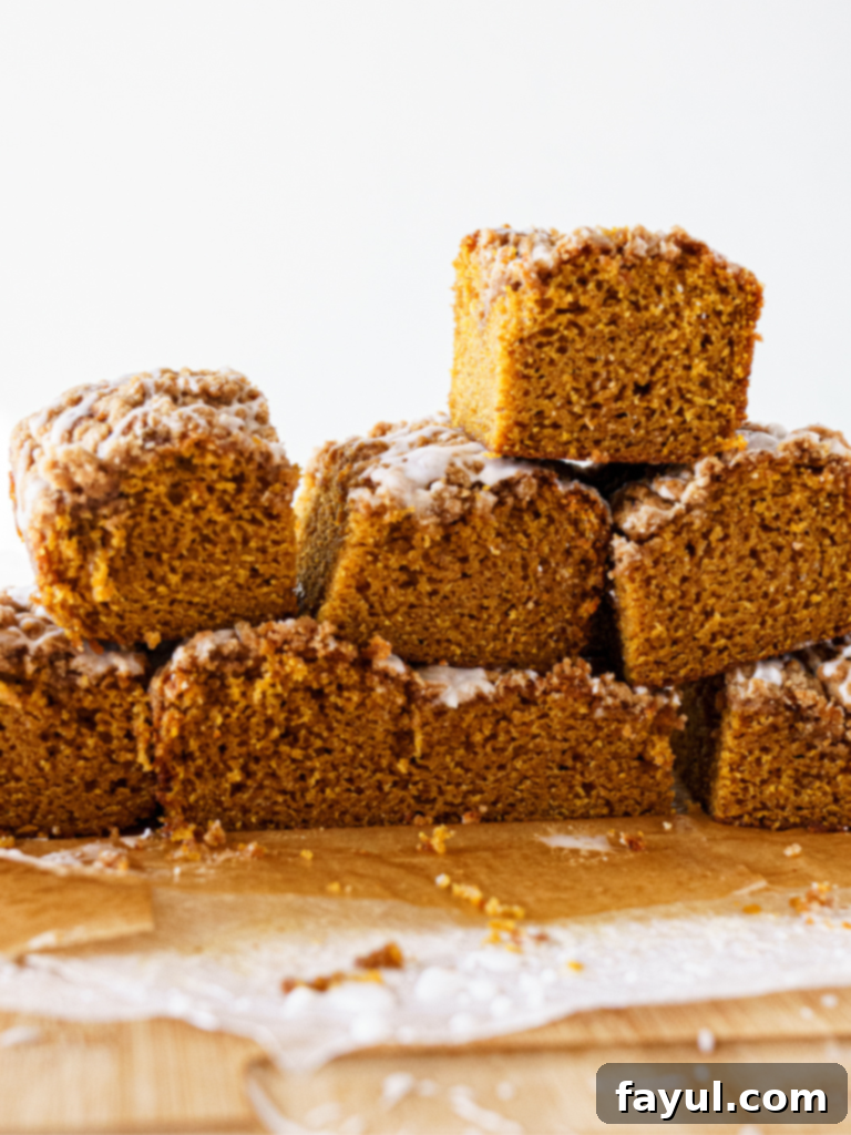 A slice of glazed pumpkin coffee cake on a plate, showing the streusel topping and moist interior.