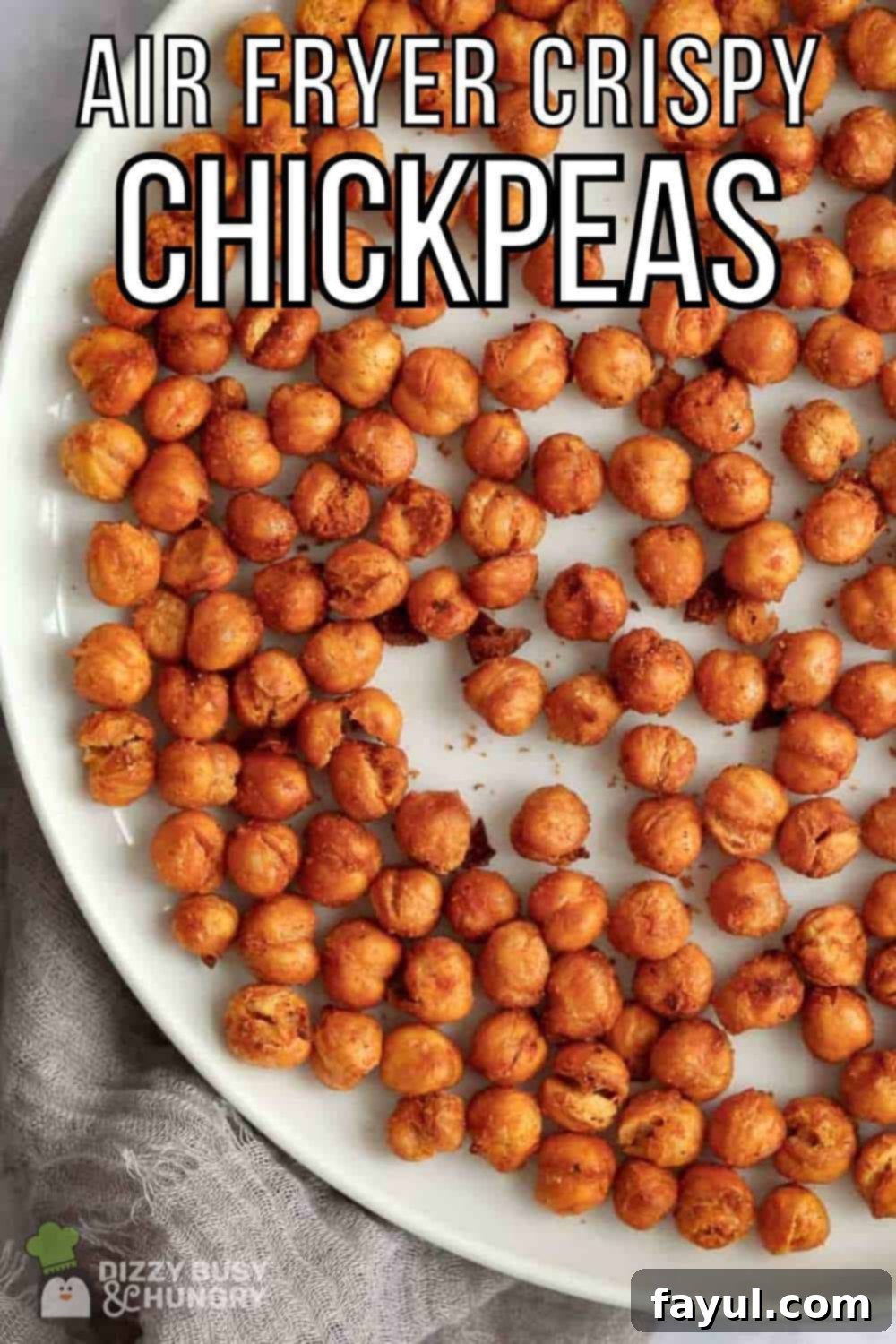 Overhead shot of crispy chickpeas on a white plate on a grey cloth.