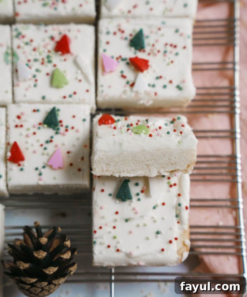 Close up of a frosted Christmas sugar cookie bar with sprinkles, ready to be served.