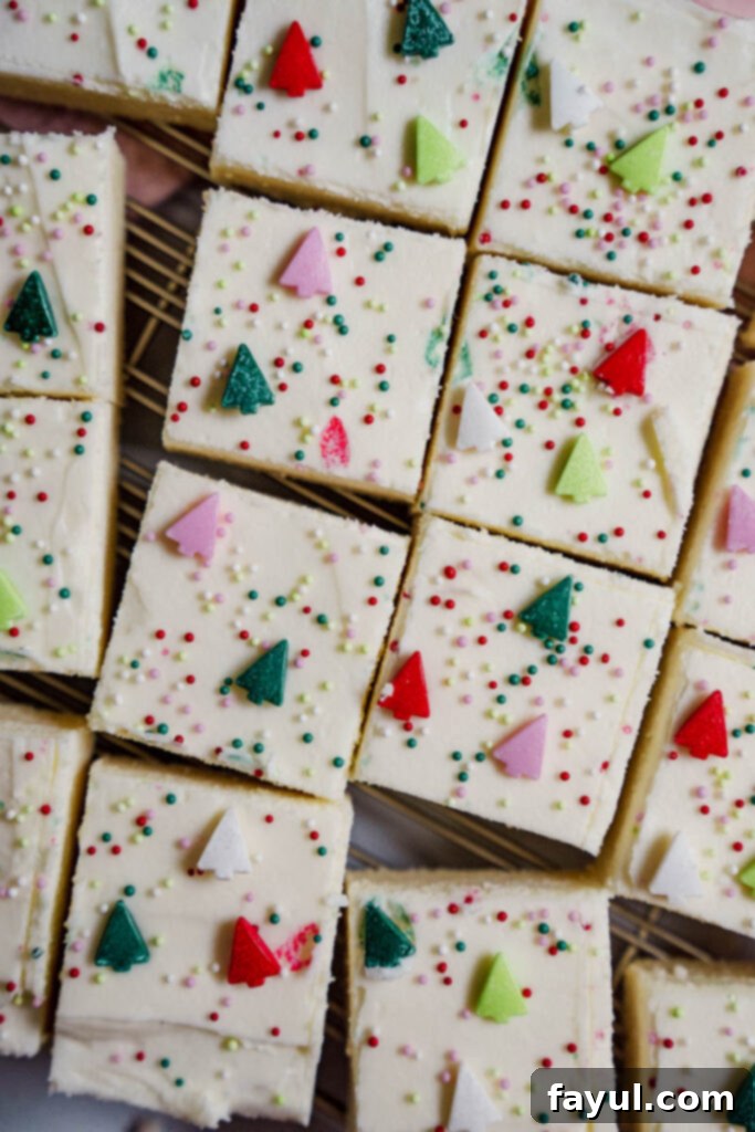 Overhead view of Christmas sugar cookie bars with sprinkles in a pan, cut into squares.