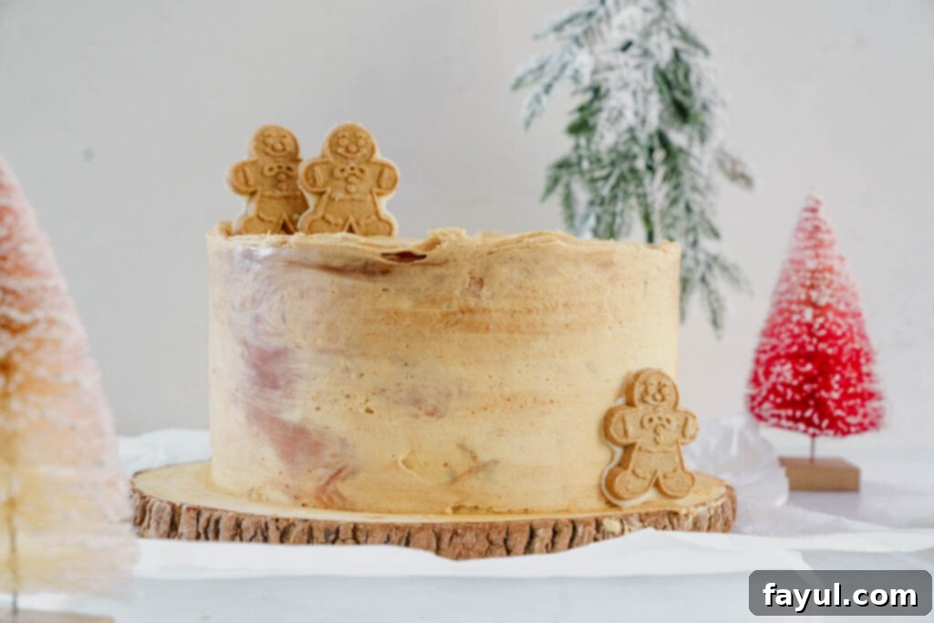 Full Caramel Gingerbread Cake on a cake stand, decorated with gingerbread cookies.