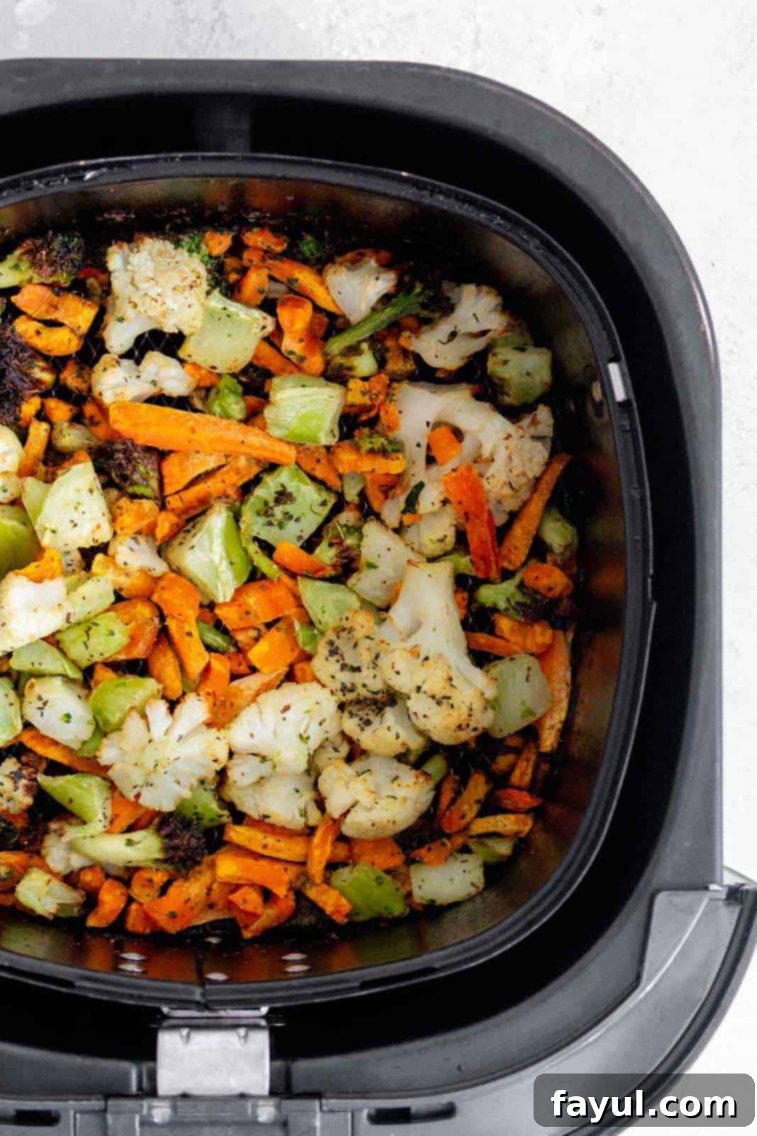 Air fryer frozen vegetables being served directly from an air fryer basket, steam rising.