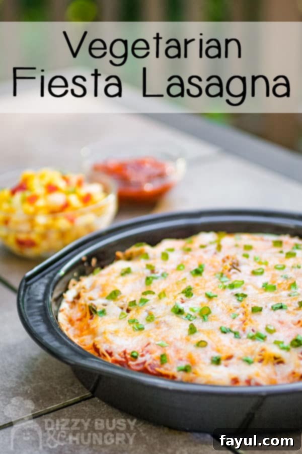 Side view of fiesta lasagna garnished with green onions in a black pan, ready to be served.