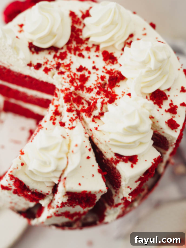 Slice of moist Red Velvet Cake with thick cream cheese frosting layers