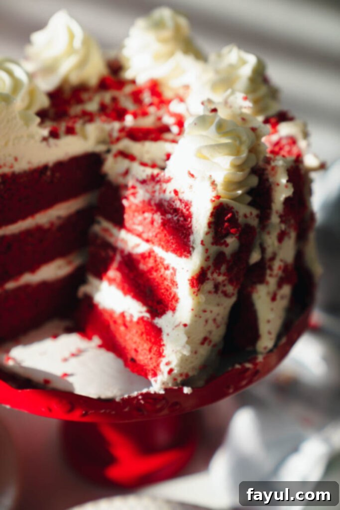 Finished Red Velvet Cake being sliced to reveal its moist layers and frosting