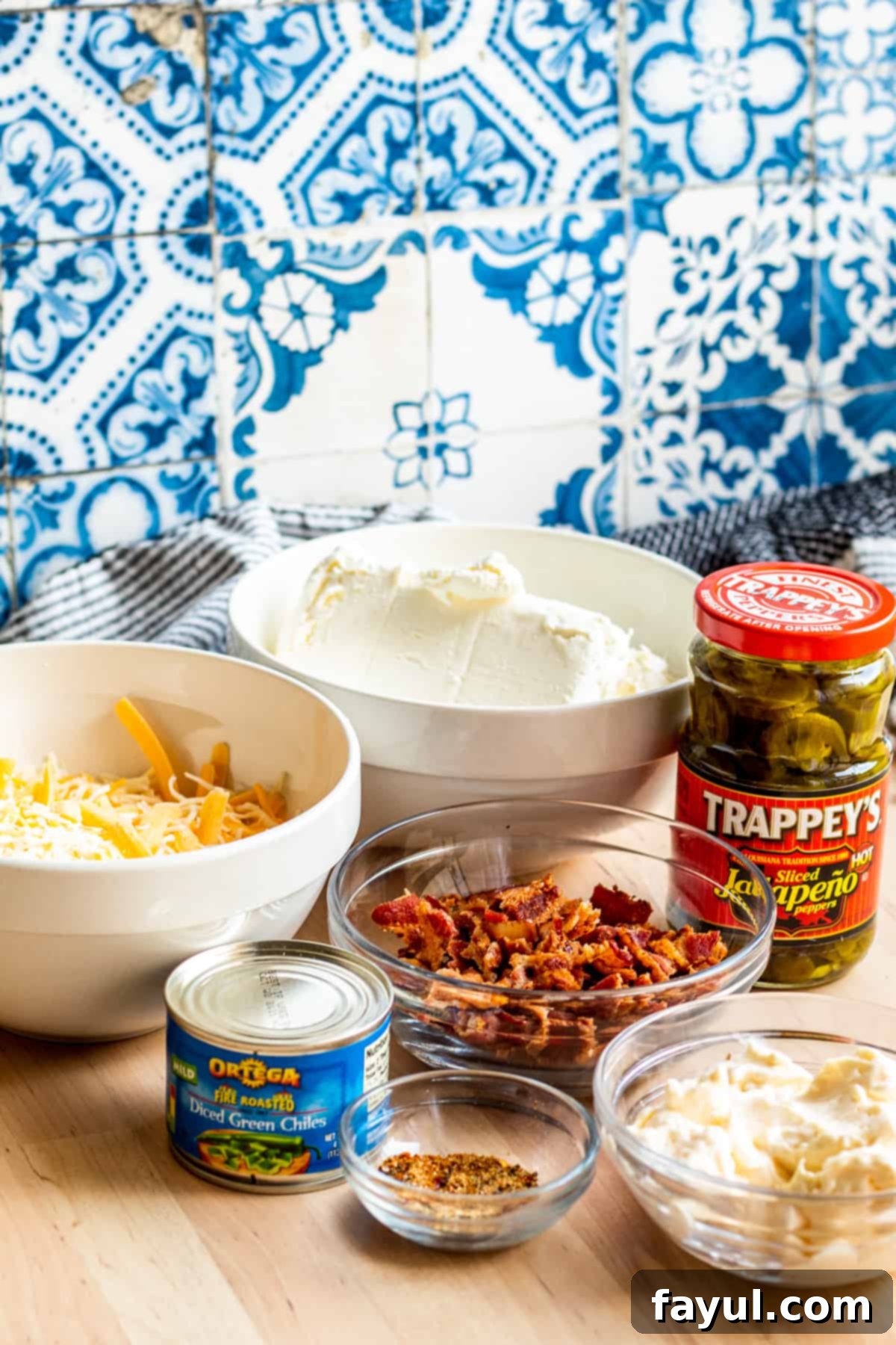 Loaded Bacon Jalapeno Burst 2 Ingredients for dip laid out on wooden table with blue and white background.