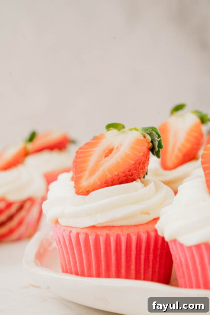 A top-down view of beautifully frosted strawberry marshmallow cupcakes, ready for serving.