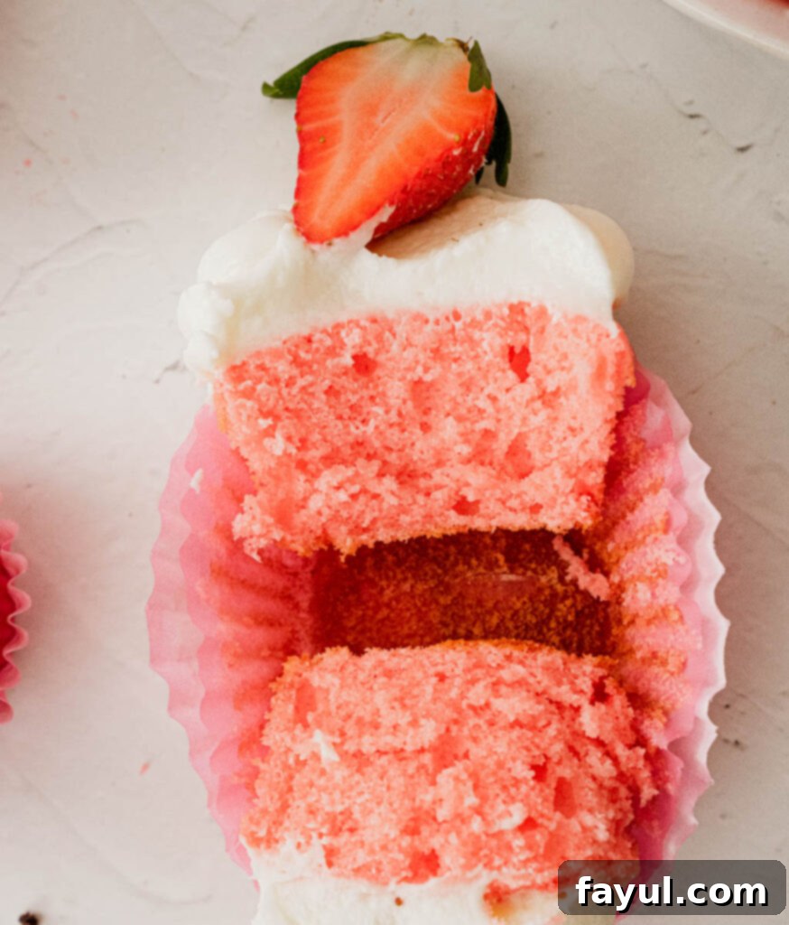 Unfrosted strawberry cupcakes showcasing their light pink crumb and perfect dome tops.