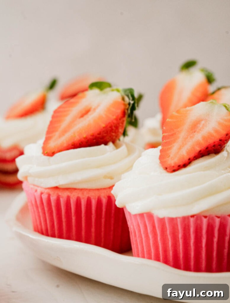 Three gorgeous strawberry marshmallow cupcakes, artfully arranged and ready to be enjoyed.