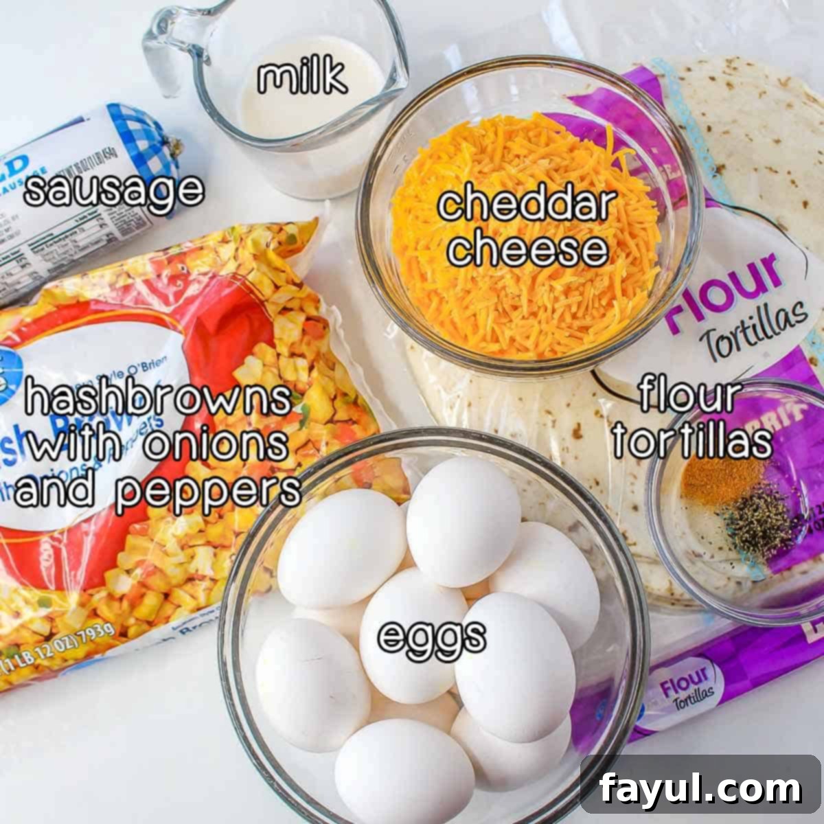 Overhead shot of ingredients - eggs, flour tortillas, cheddar cheese, milk, sausage, and hashbrowns with onions and peppers.
