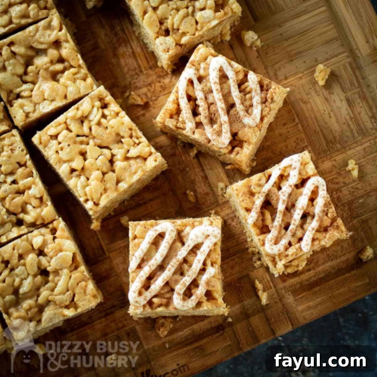 Overhead shot of Peanut Butter Rice Krispie treats with icing drizzle on a wooden cutting board, showcasing the finished product.