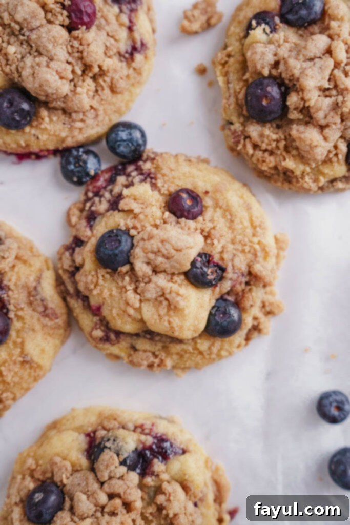 Close-up of a single lemon blueberry muffin cookie, showcasing the intricate streusel and jam swirl.