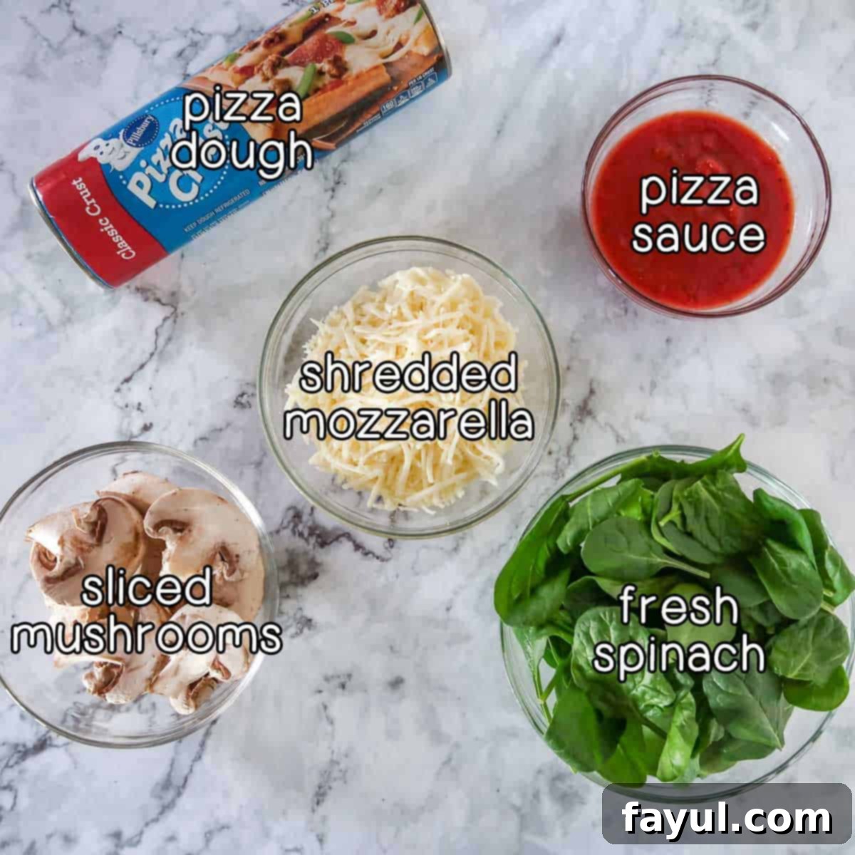 Overhead shot of ingredients - pizza dough, pizza sauce, shredded mozzarella, fresh spinach, and sliced mushrooms.