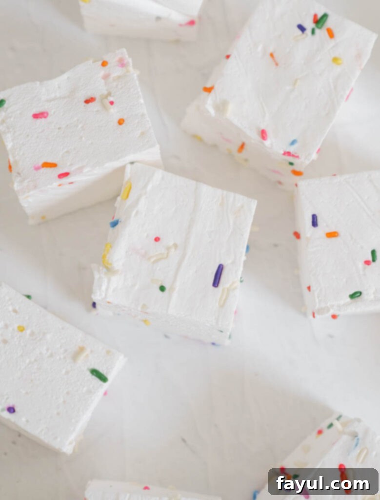 Homemade marshmallow mixture being poured into a prepared pan.