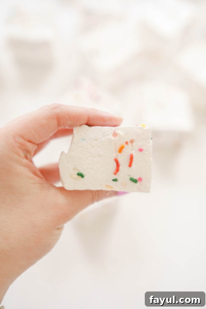 Marshmallow mixture smoothed in a pan and covered with plastic wrap.