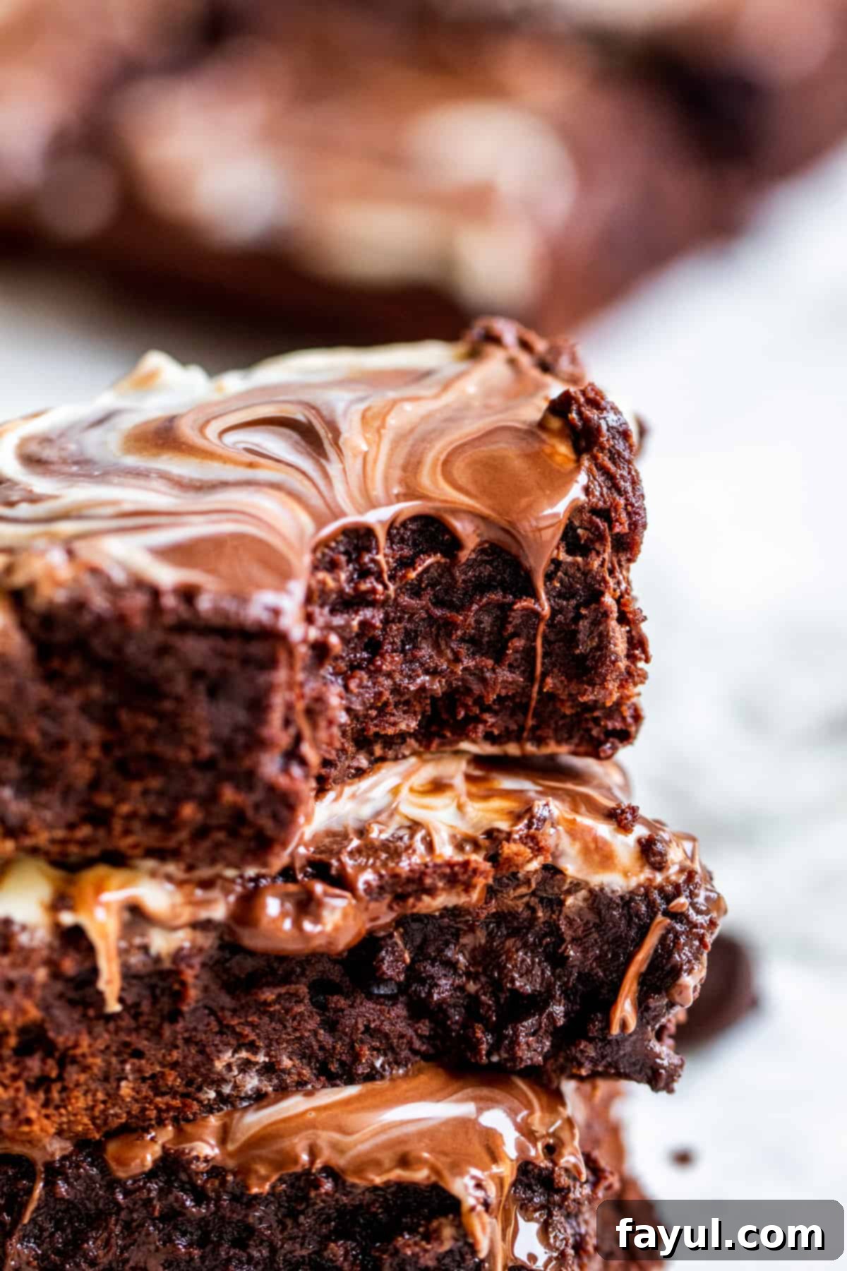 Stack of brownies with bite out of top one.