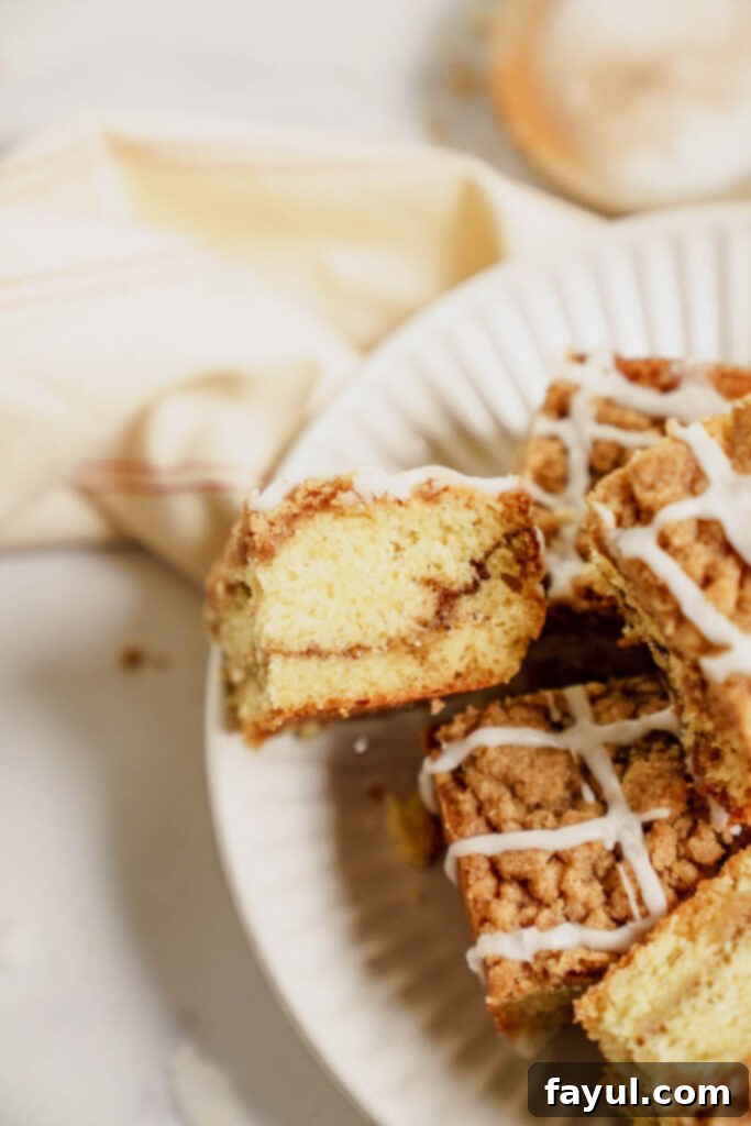 A slice of coffee cake on a plate with a fork