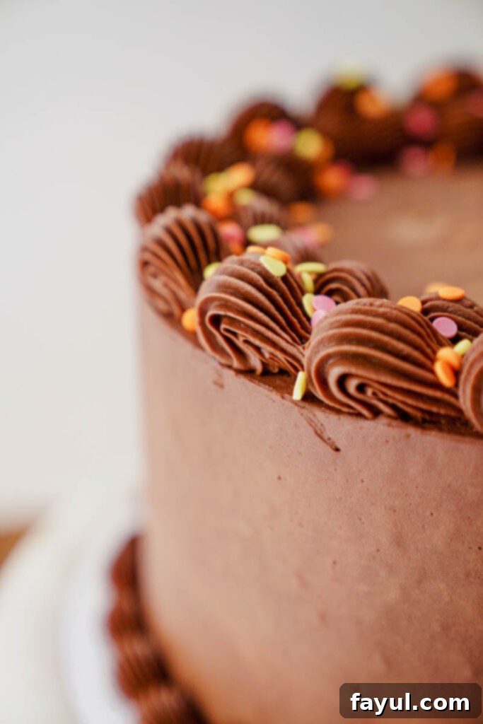 Yellow cake slice with chocolate frosting on a plate