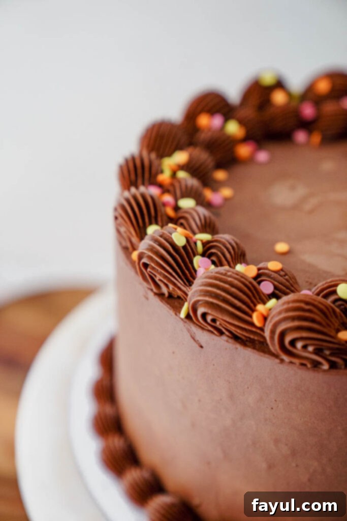 Whole yellow cake with chocolate frosting on a cake stand