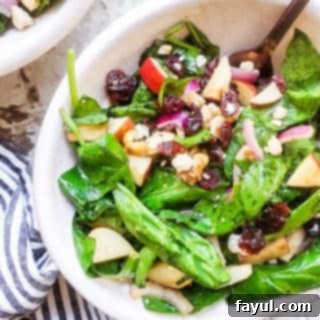 Orchard Greens with Honey Balsamic Drizzle 6 Salad in a white bowl with gold fork in it on a white counter.