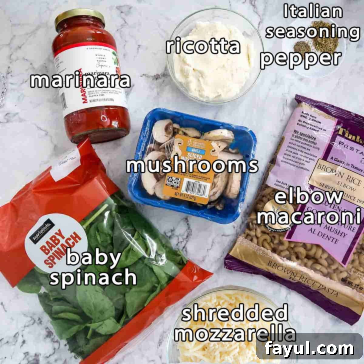 Overhead shot of ingredients - marinara, ricotta, mushrooms, baby spinach, shredded mozzarella, elbow macaroni, Italian seasoning, and pepper.