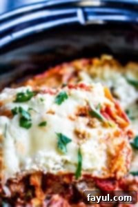 A slice of vegetarian lasagna being lifted out of the crockpot with a spatula, showing the layers.