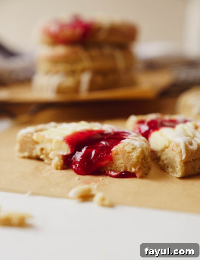 Pile of cherry cheesecake cookies, some with a drizzle