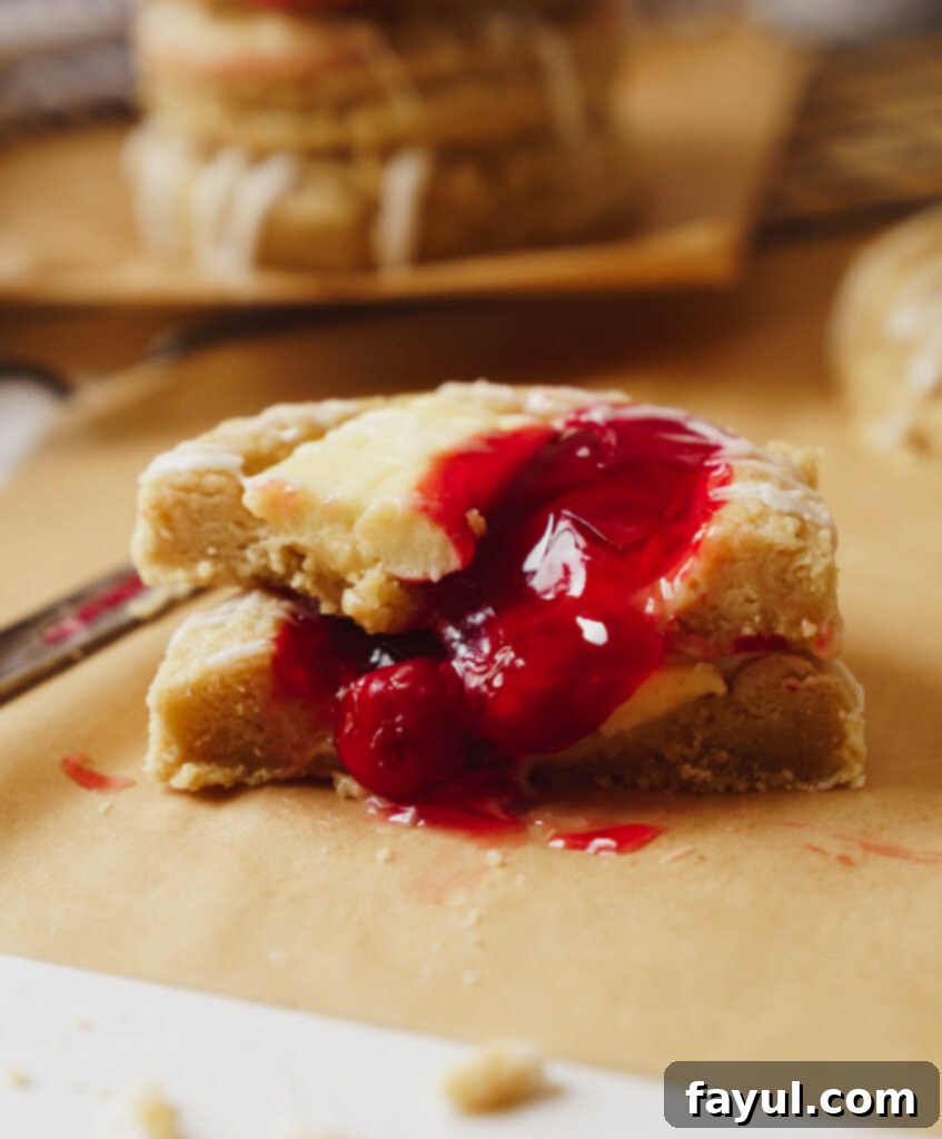 Hand placing cherry cheesecake cookie on a wire rack to cool