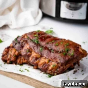 Side close up shot of multiple ribs garnished with parsely on a piece of butcher paper on a wooden cutting board.
