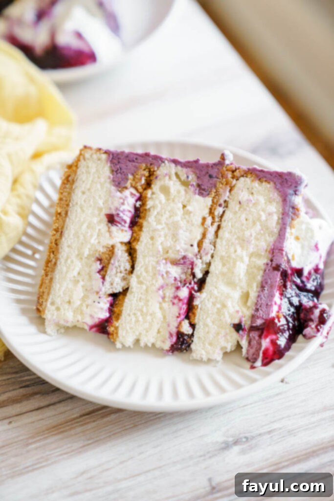 Full blueberry cheesecake cake on a stand, ready for serving