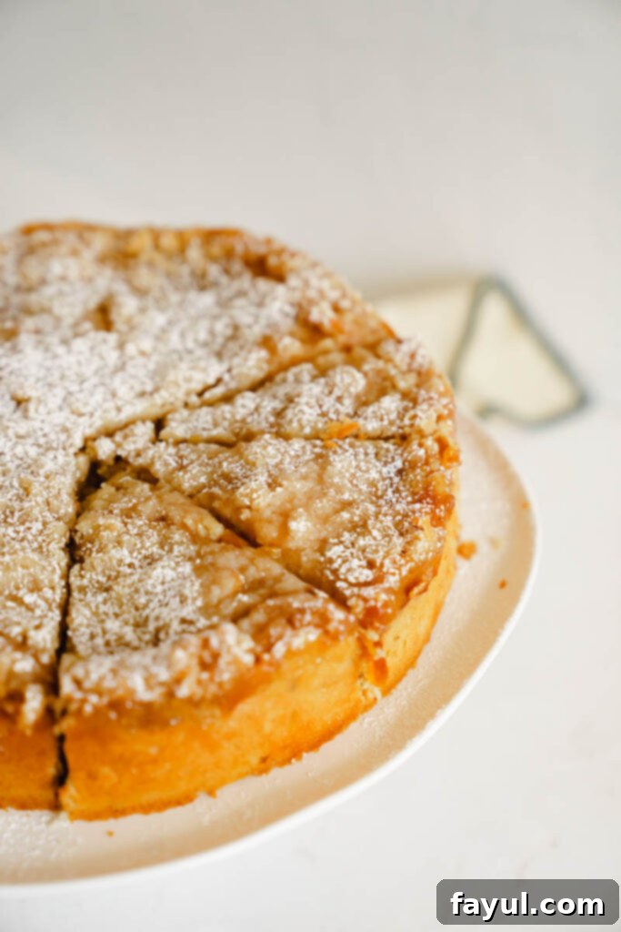 Overhead shot of a sliced peach cobbler cake, showing the filling and streusel