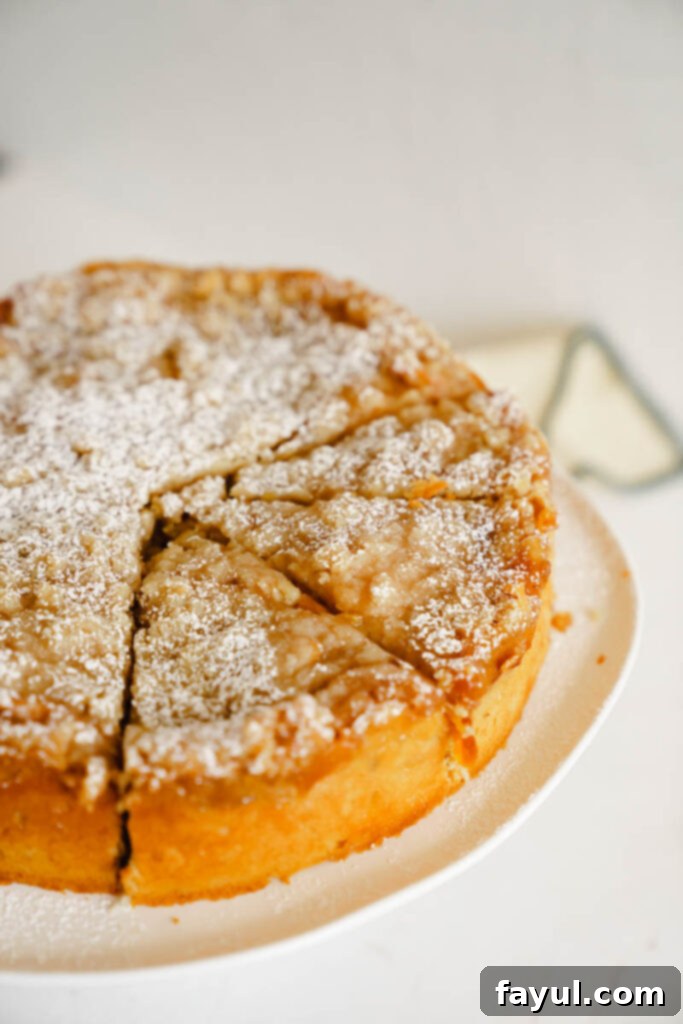 Side view of a whole peach cobbler cake, showing its height and topping