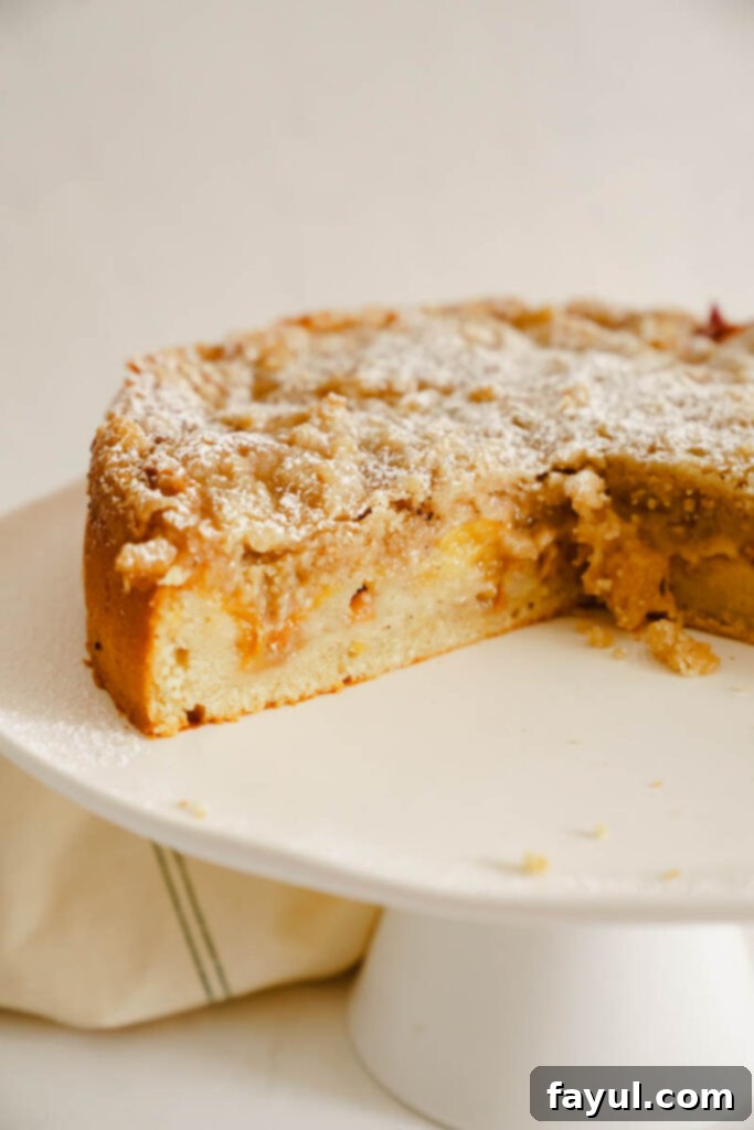 A whole peach cobbler cake cooling on a wire rack