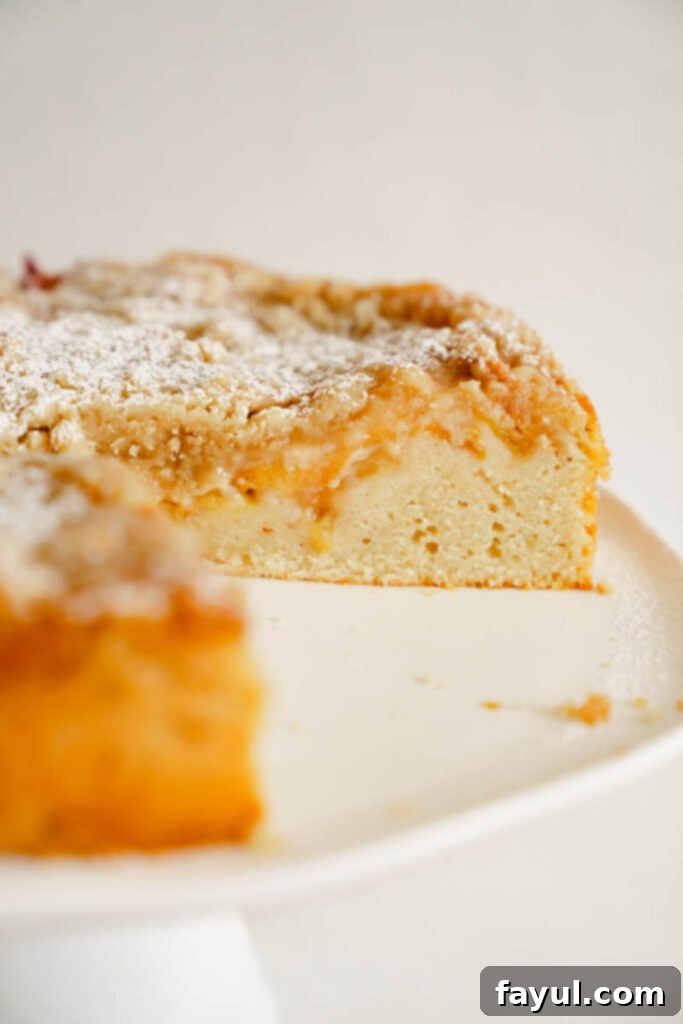 Two slices of peach cobbler cake on white plates